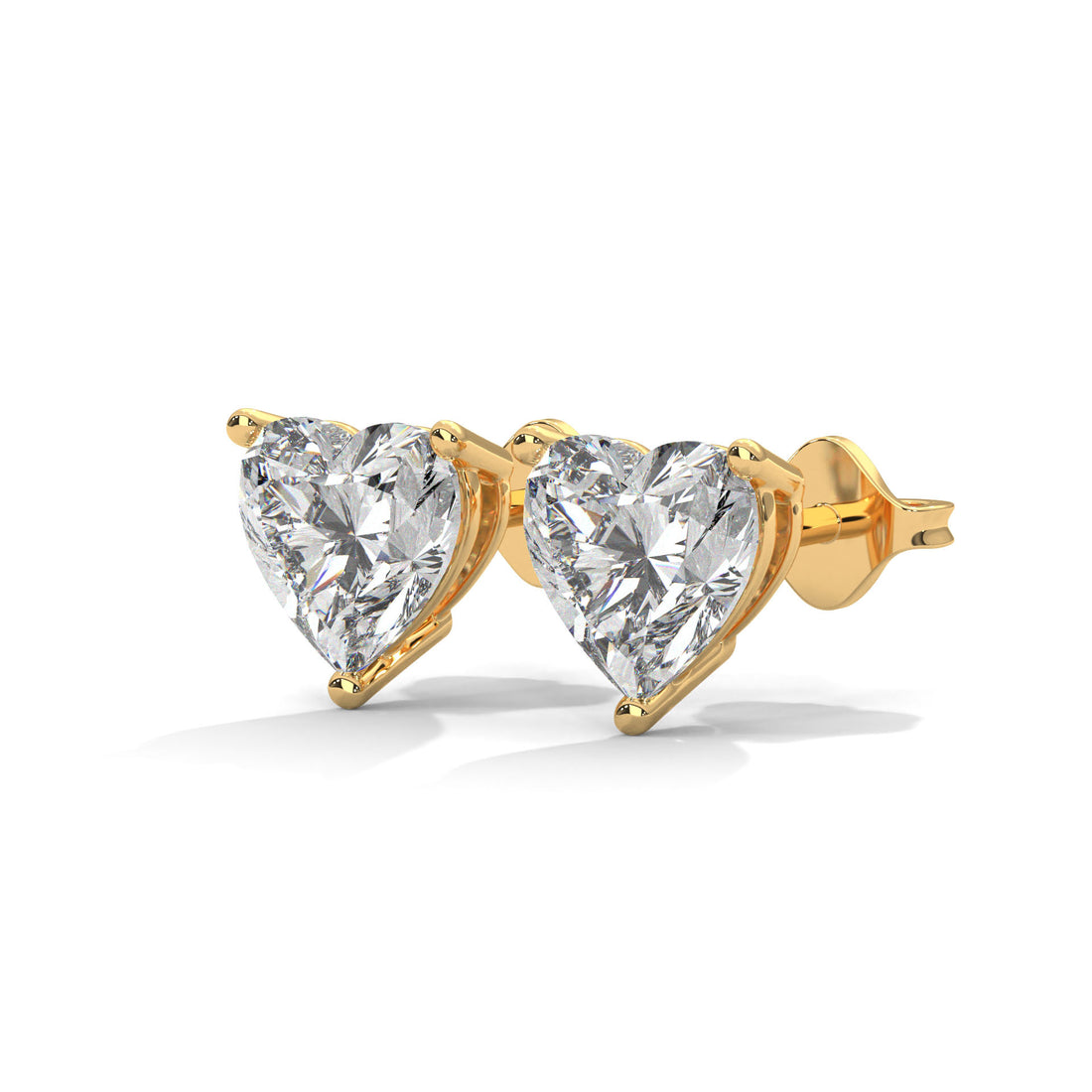 Heart-shaped diamond earrings with gold prongs on a white background