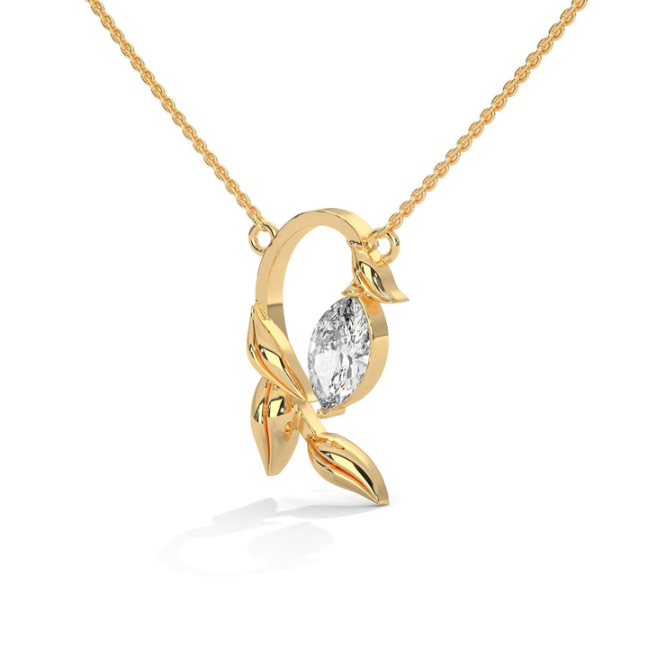Gold necklace with a leaf-shaped pendant featuring a diamond on a white background