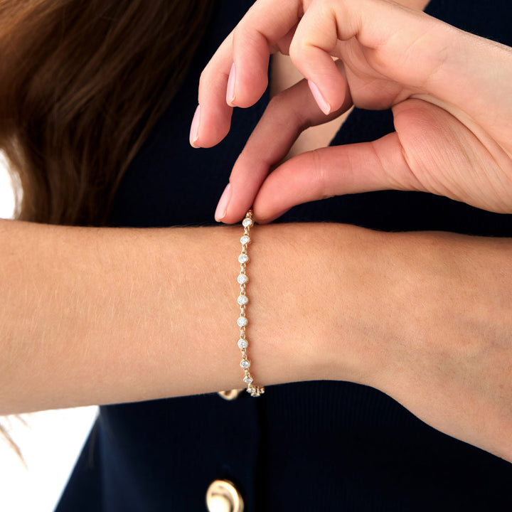 Close-up of a hand wearing a pearl bracelet on a dark background