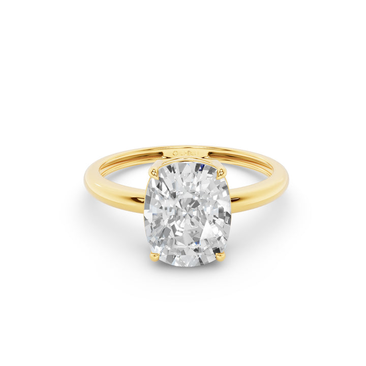 Gold ring with a large diamond held between fingers against a blurred background