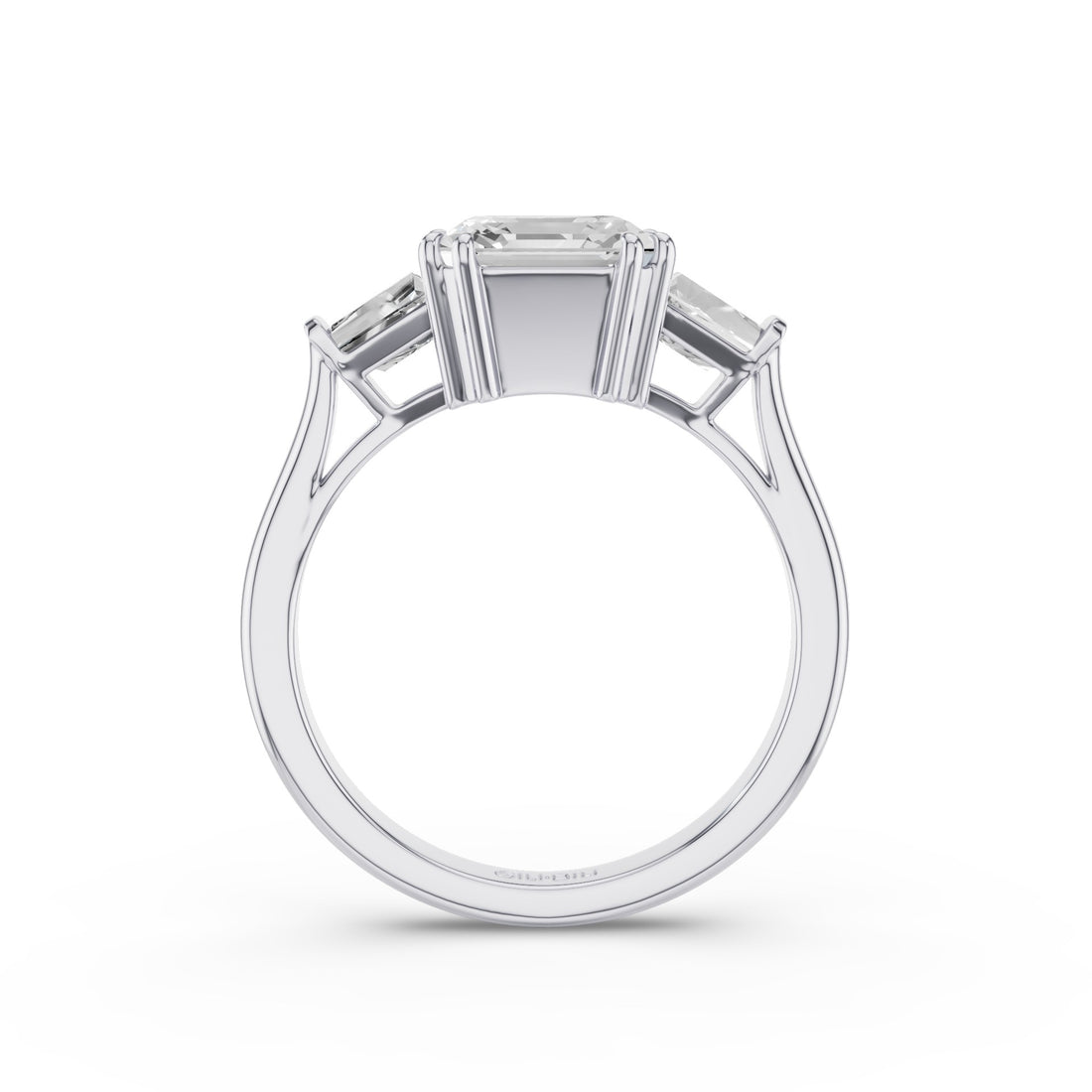 A three-stone diamond ring in a polished silver-colored metal, featuring a central rectangular Asscher cut diamond flanked by two smaller tappered-cut diamonds, shown against a plain white background.