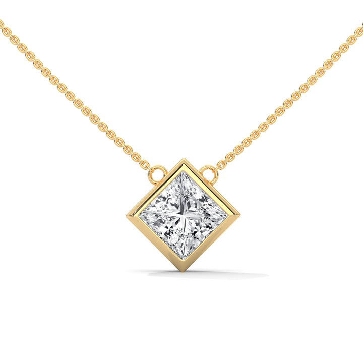 Gold necklace with princess cut diamond pendant on a white background