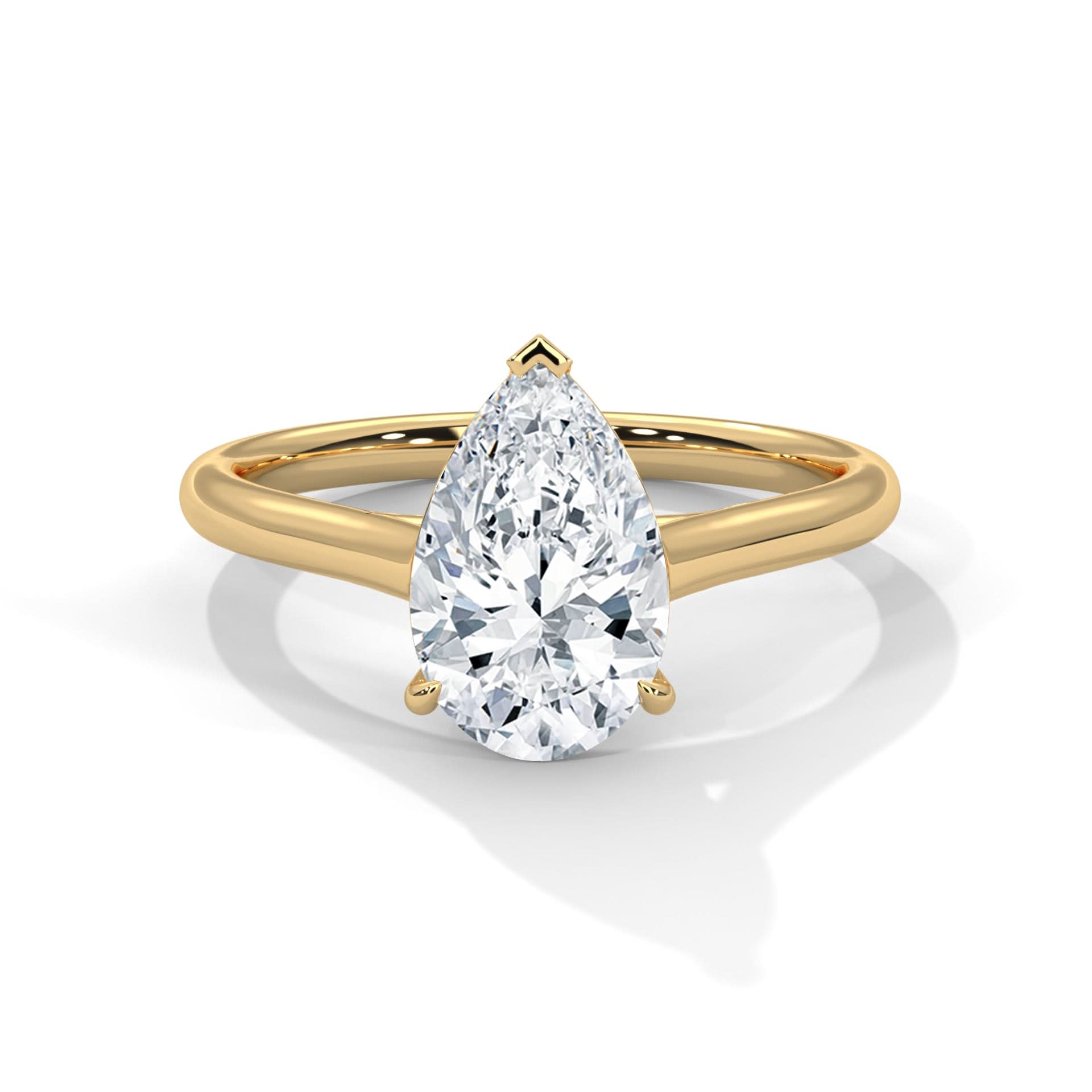 Gold ring with a pear-shaped diamond on a white background