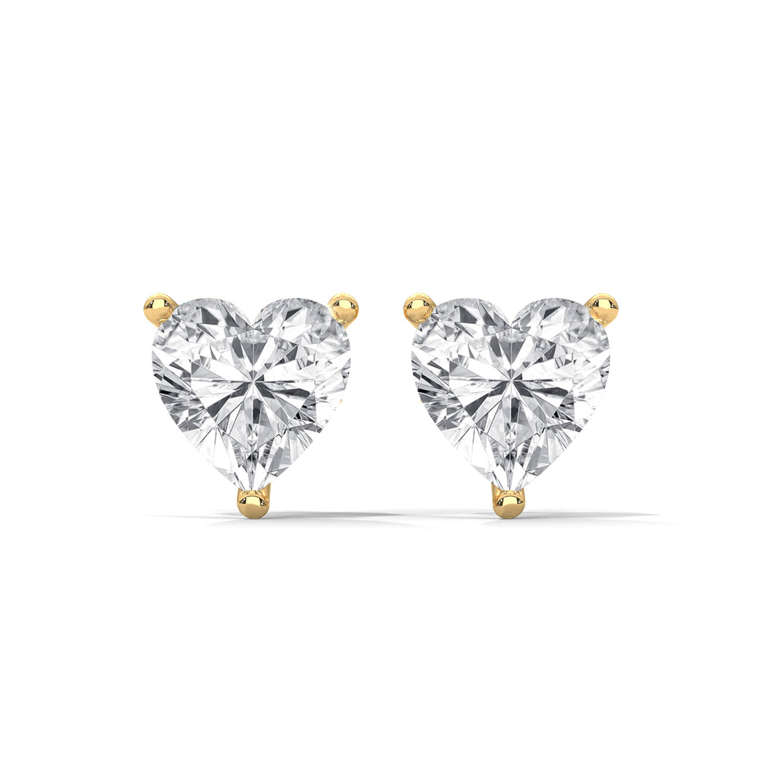 Heart-shaped diamond earrings with gold prongs on a white background