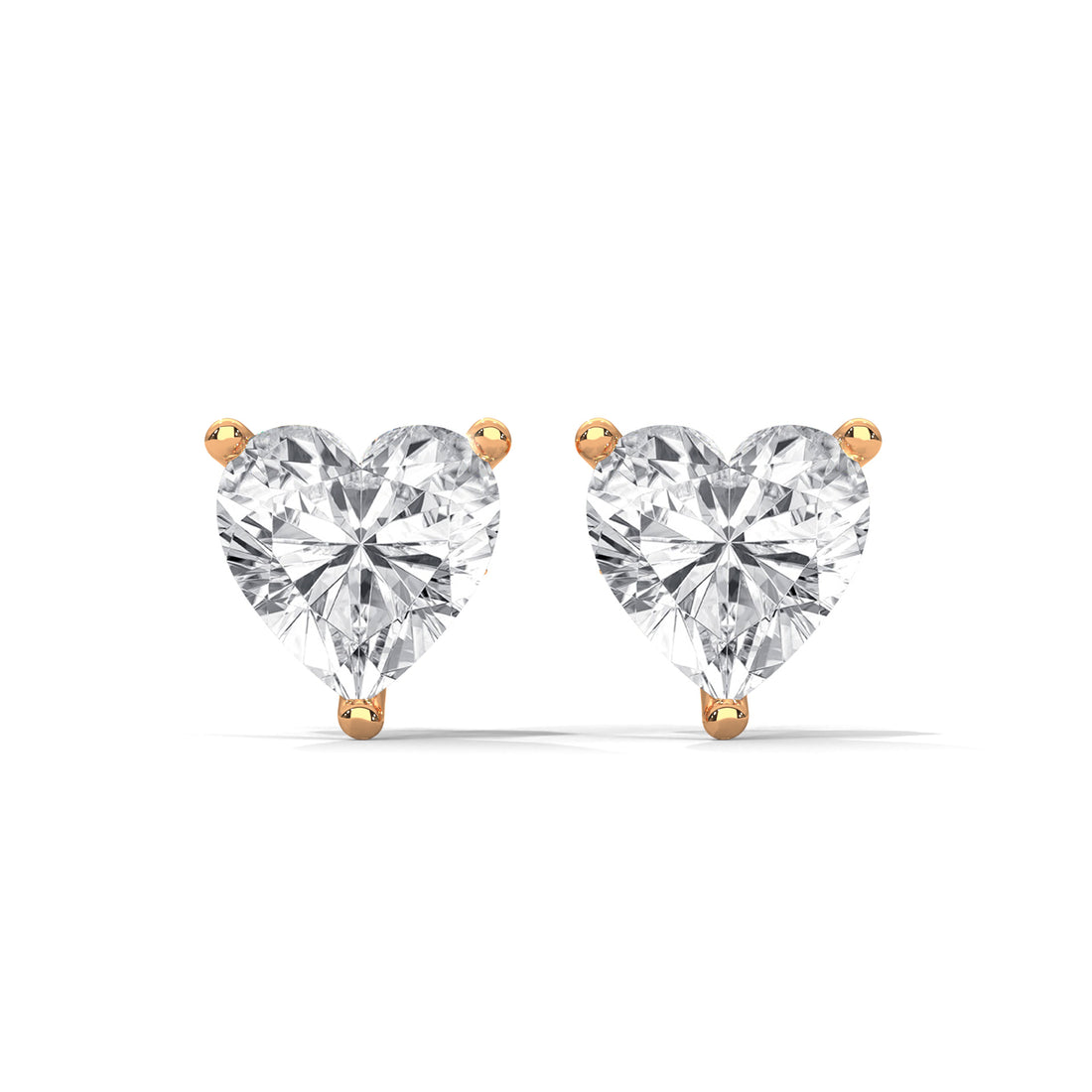 Heart-shaped diamond earrings with gold prongs on a white background