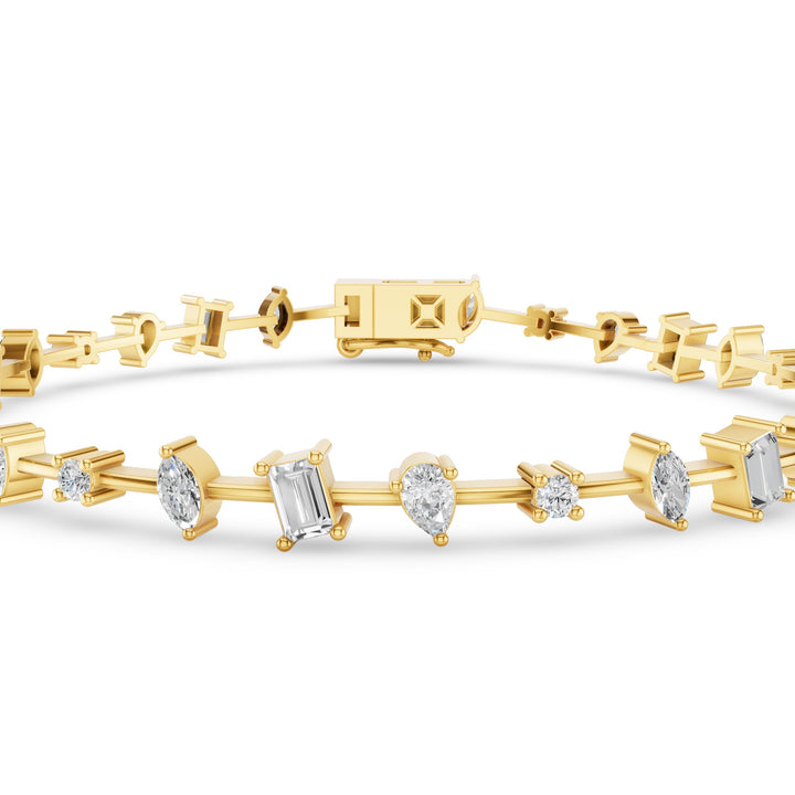 A yellow gold tennis bracelet featuring a row of clear gemstones in baguette, pear, and round cuts, displayed on a clean white background.