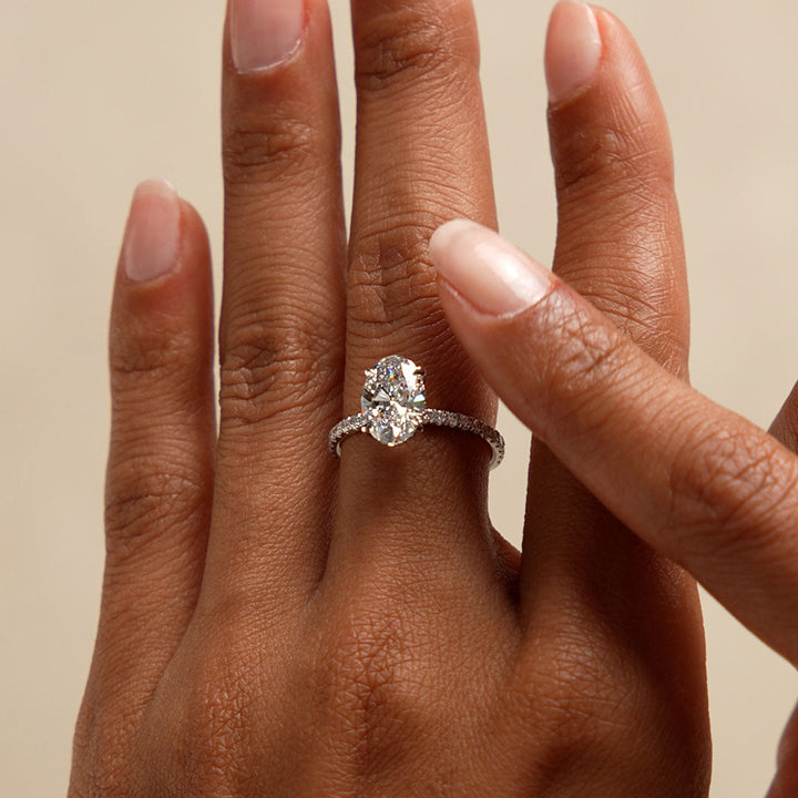 Diamond ring on a hand with a beige background