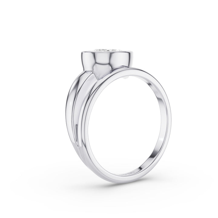 A polished silver-toned ring with a wide band and a small round clear gemstone set in a bezel-like top, shown on a clean white background.