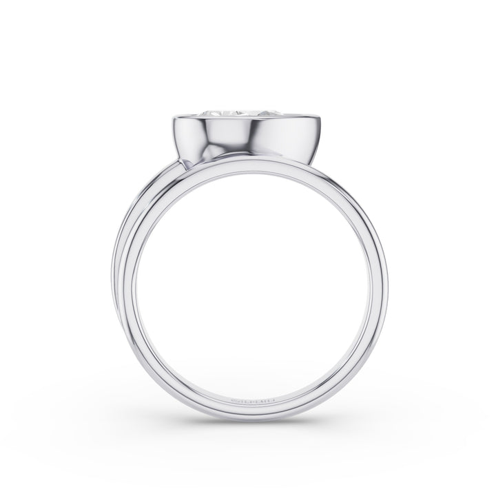 A silver-toned ring with a wide, polished band and a small, round clear gemstone set in a smooth bezel at the top, shown against a plain white background.
