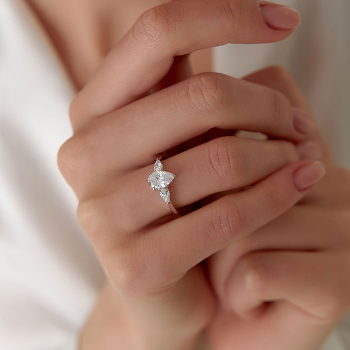 Close-up of a hand wearing a diamond ring with a blurred background