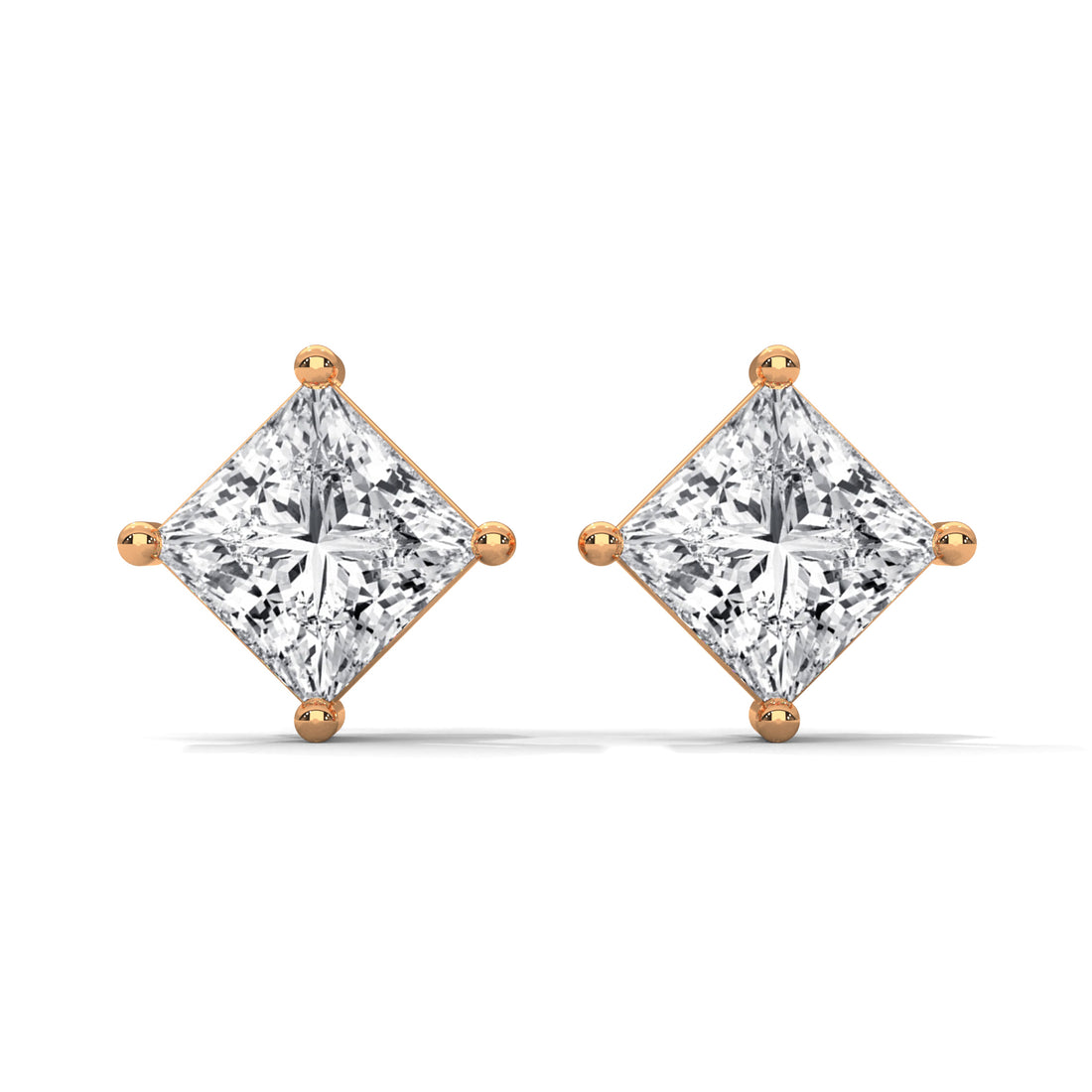 Pair of diamond earrings with rose gold prongs on a white background