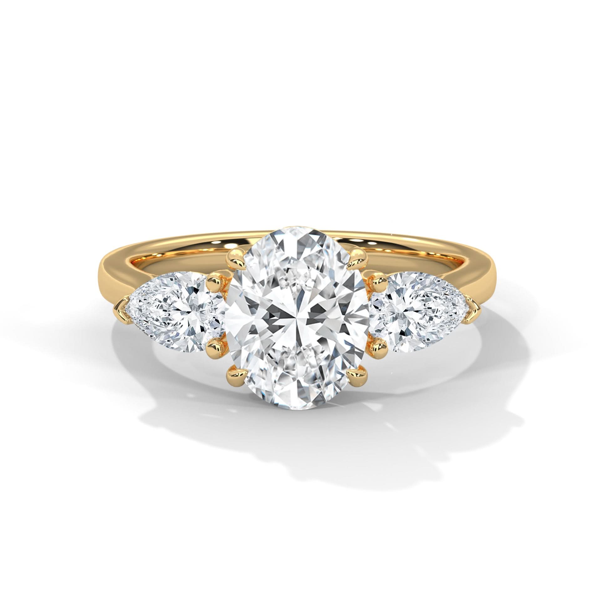 Gold ring with a Oval diamond and two pear-shaped diamonds on a white background