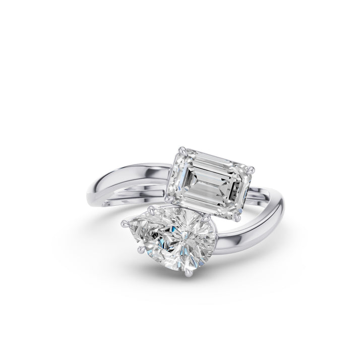 A silver-tone ring featuring a large rectangular emerald-cut diamond and a smaller pear-cut diamond, set on a polished band against a clean white background.